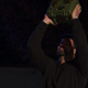 Blake holds a boombox over his head while staring up at Katie's balcony of deep thoughts